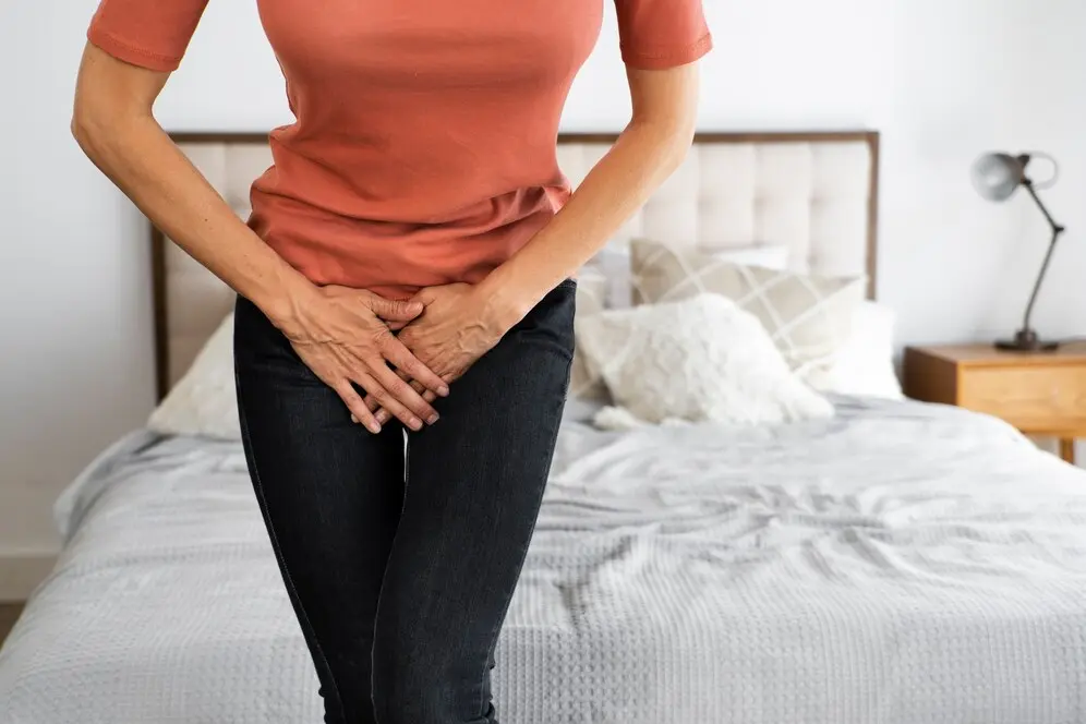 how-to-get-rid-of-a-uti-in-kendall woman with a UTI in kendall crossing arms over pelvis