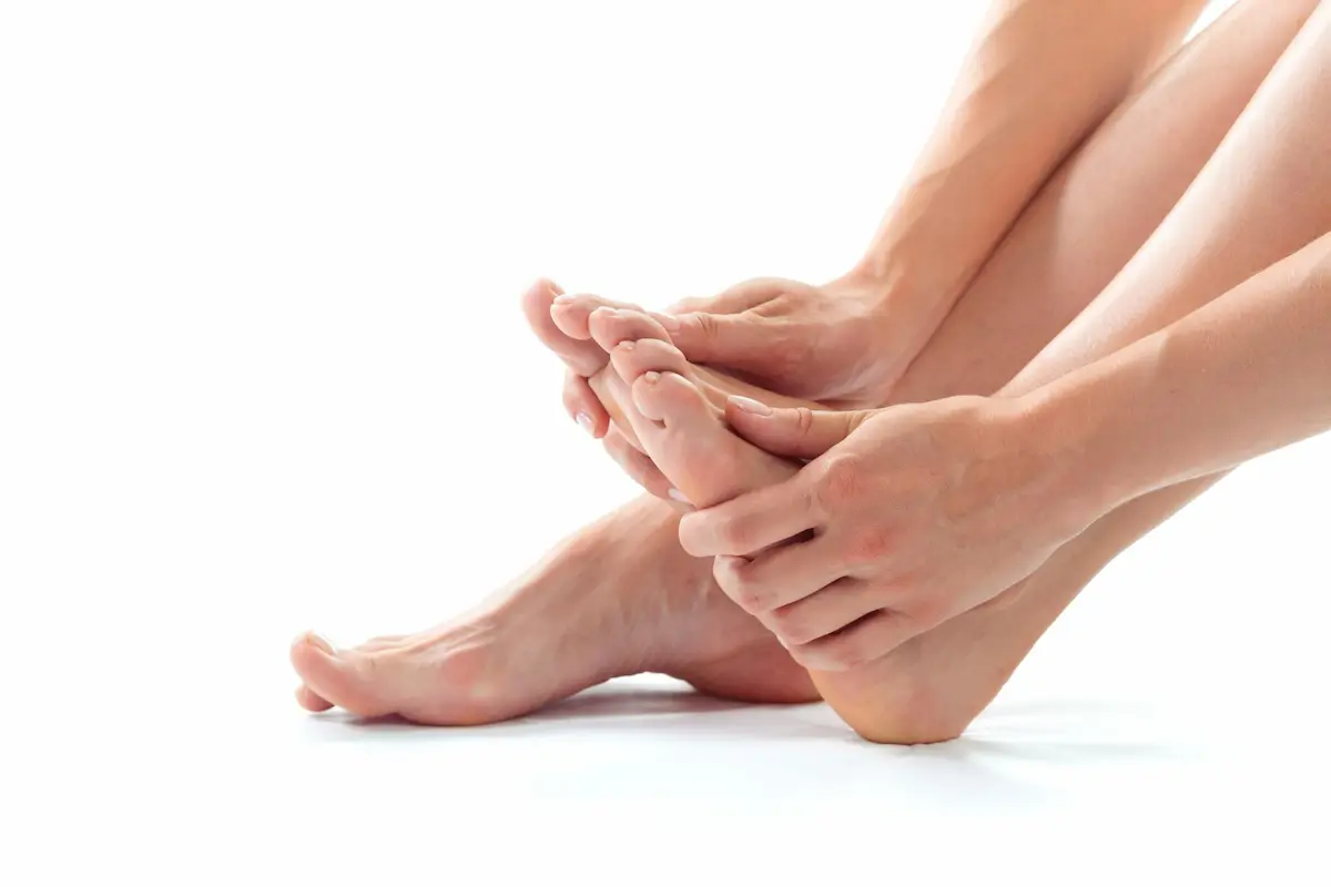 woman massaging her feet to improve circulation in feet