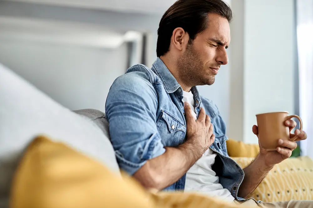 a man clutching his chest wondering how long a heart attack lasts