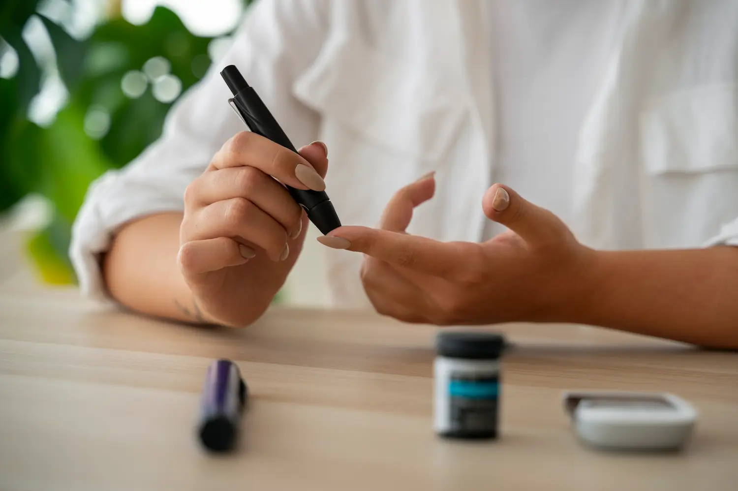 a woman practicing type 2 diabetes self care by pricking her finger