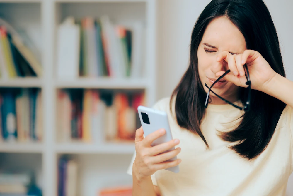 A woman with eye strain from phone